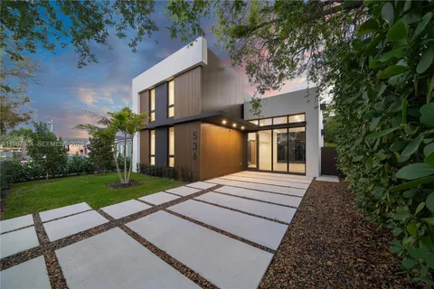 front view of a house with a yard and an outdoor seating
