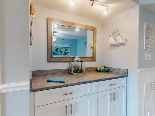 a kitchen with stainless steel appliances kitchen island granite countertop a dining table chairs and white cabinets