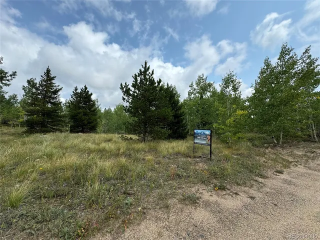 a view of a yard with wooden fence