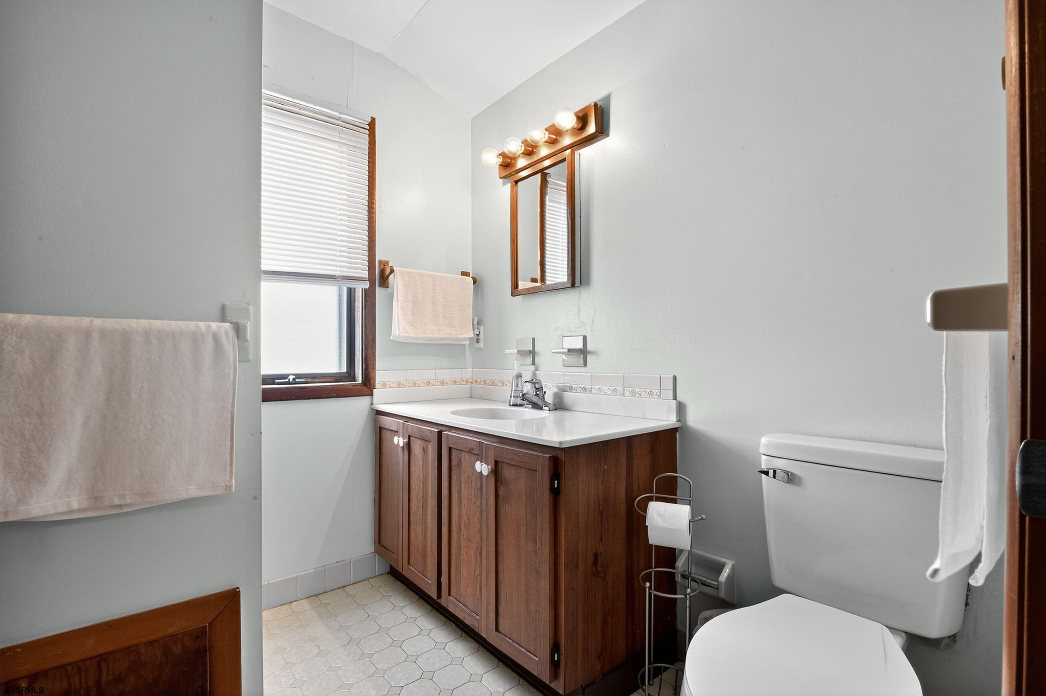 22 Williams Avenue Strathmere, NJ 08248 - Photo 19 of 40 a bathroom with a toilet a sink a vanity and mirror