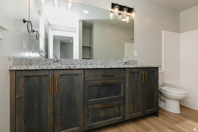 226 South 600 West Logan, UT 84321 - Photo 20 of 25 Full bathroom featuring double vanity, light wood-style flooring, and shower combination