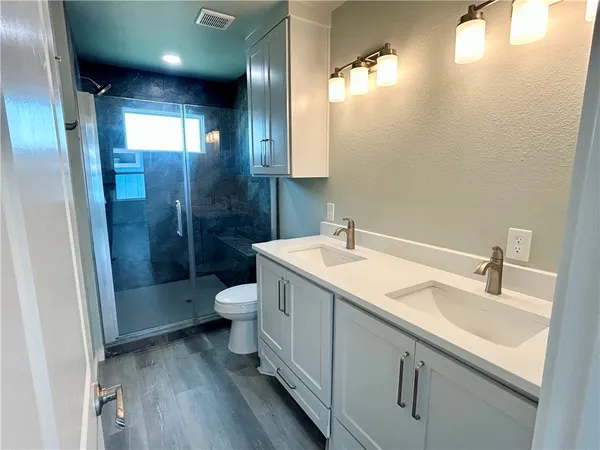 a bathroom with a sink a toilet and shower