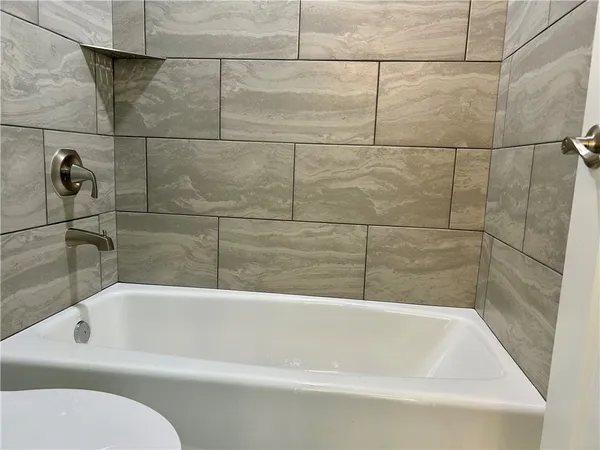 a bathroom with a white bath tub and shower