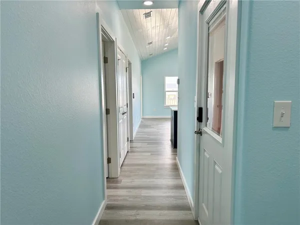 a view of a hallway with wooden floor and staircase