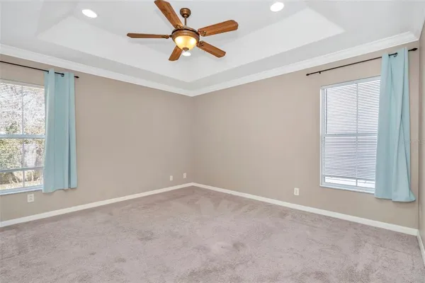 an empty room with windows and fan
