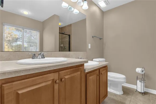 a bathroom with a granite countertop sink a toilet and a mirror