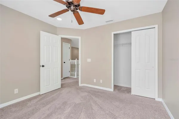 a view of a room with a ceiling fan and closet