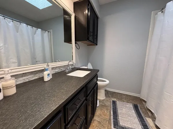 a bathroom with a granite countertop sink and a mirror