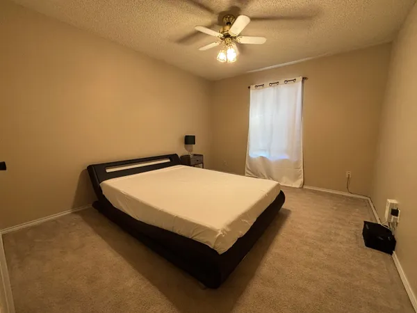 a bed sitting in a spacious bedroom next to a window