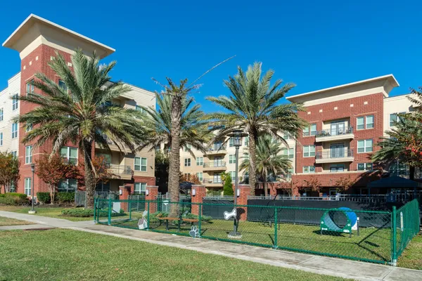a front view of multi story residential apartment building with yard and green space