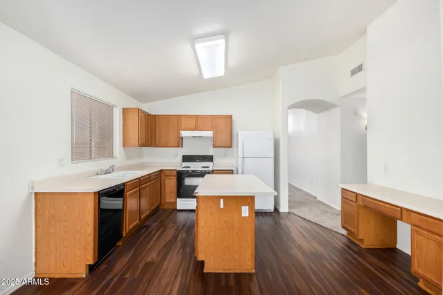 a kitchen with a sink stove and wooden floor
