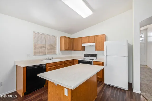 a kitchen with stainless steel appliances a stove a refrigerator white cabinets and wooden floor