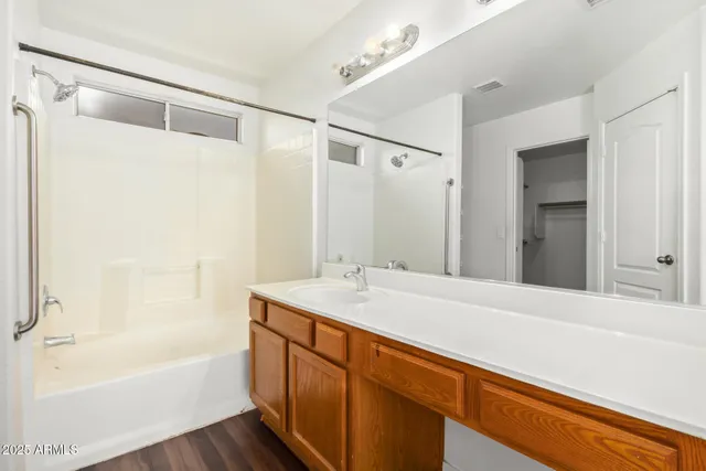 a bathroom with a granite countertop sink and a bathtub