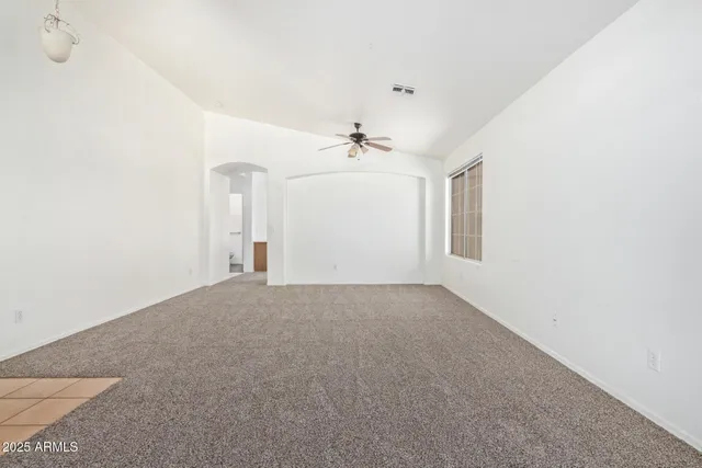 a view of a room with a ceiling fan and window