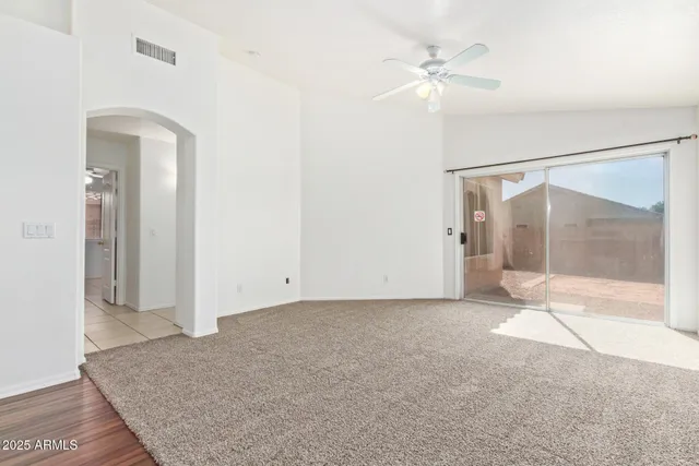 an empty room with fan and entrance