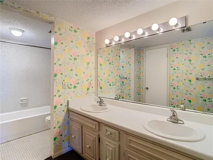 a bathroom with a double vanity sink mirror and shower