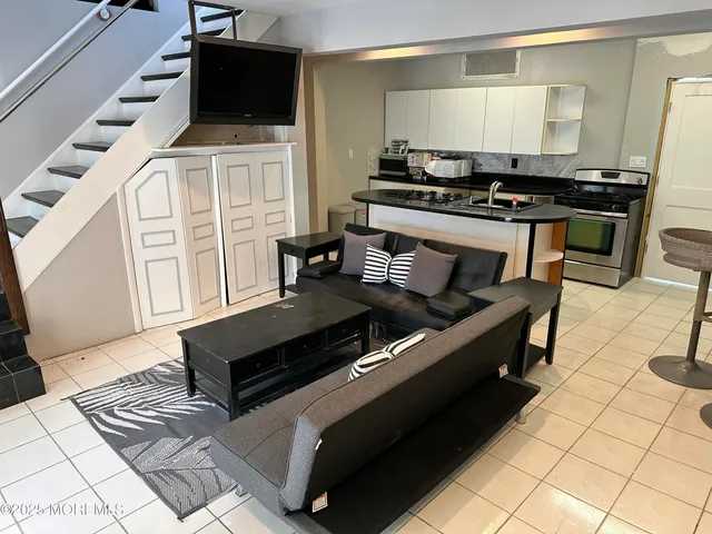 a kitchen with stainless steel appliances kitchen island granite countertop a stove a sink and a microwave