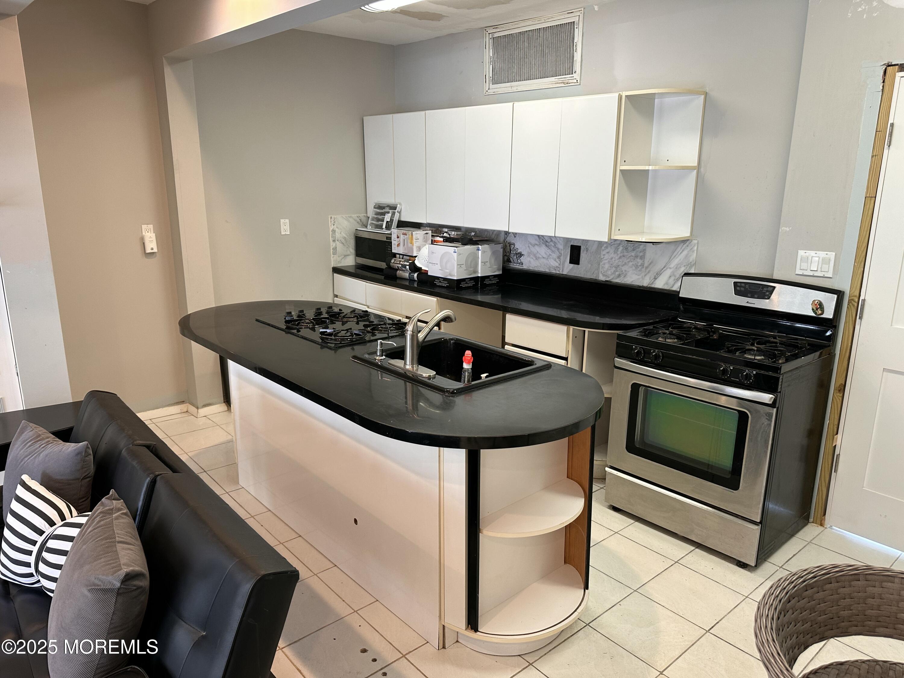 116 12th Avenue, Unit FRONT Belmar, NJ 07719 - Photo 3 of 7 a kitchen with stainless steel appliances granite countertop a stove and a sink