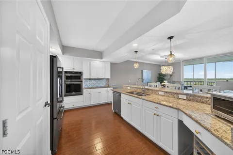 a large kitchen with granite countertop a lot of counter space and stainless steel appliances