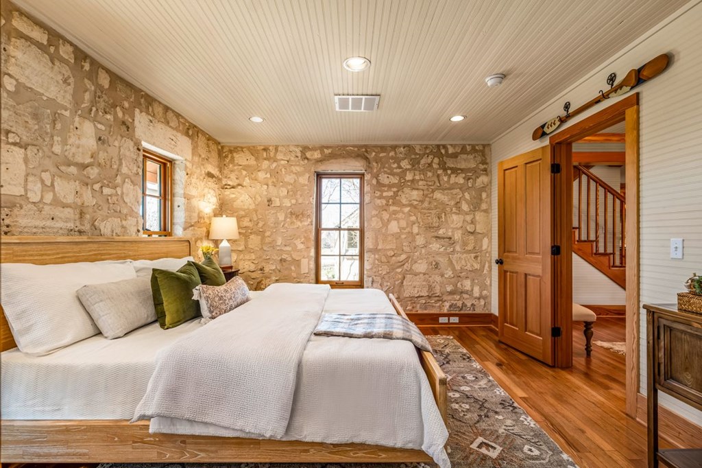 9402 Doss-Spring Creek Road Doss, TX 78618 - Photo 20 of 78 a spacious bedroom with a large bed and a large window