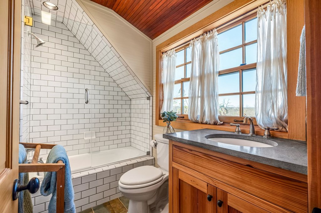 9402 Doss-Spring Creek Road Doss, TX 78618 - Photo 30 of 78 a bathroom with a granite countertop bathtub sink vanity mirror and toilet
