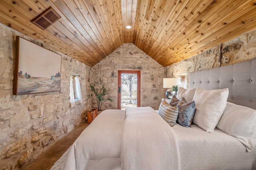 9402 Doss-Spring Creek Road Doss, TX 78618 - Photo 44 of 78 a large bed sitting in a bedroom next to a bathroom