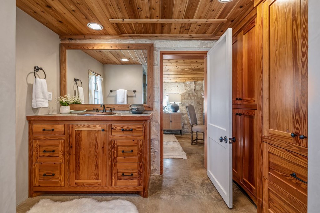 9402 Doss-Spring Creek Road Doss, TX 78618 - Photo 48 of 78 a bathroom with a granite countertop sink a mirror and a vanity