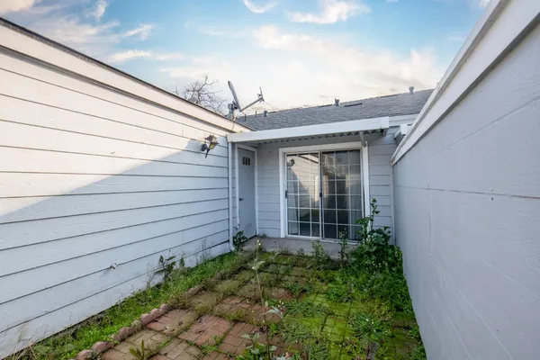 a view of a house with a small yard and wooden floor and fence