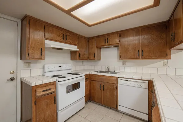 a kitchen with a stove sink and cabinets