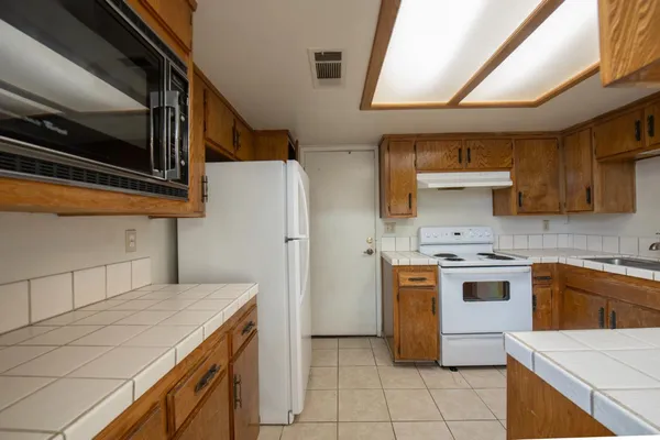 a kitchen with stainless steel appliances granite countertop a sink and a stove