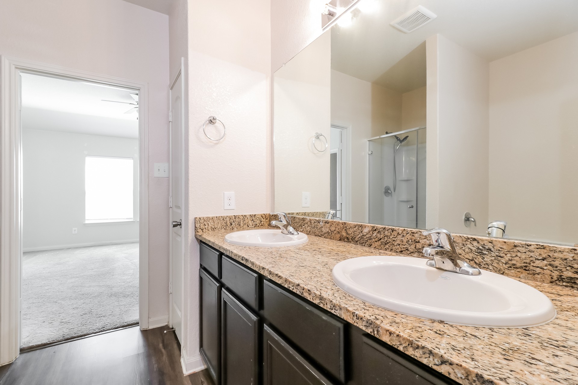 20017 Hubert R Humphrey Road Manor, TX 78653 - Photo 12 of 27 Double vanity with granite counters and rich cabinetry in this primary bathroom.