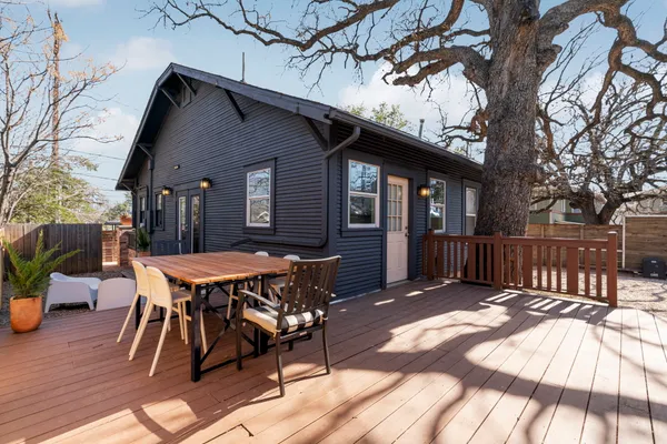 a view of backyard with deck and outdoor seating