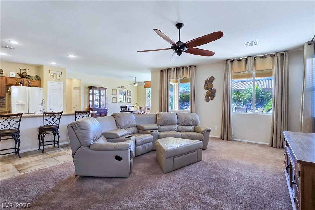 2485 Morrow Ridge Place Laughlin, NV 89029 - Photo 10 of 40 An inviting great room with soft carpeting and large windows, perfect for relaxation and everyday living.