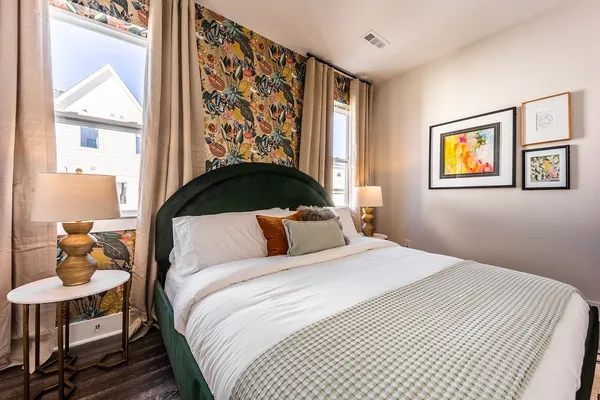 a bedroom with a bed and a painting on the wall