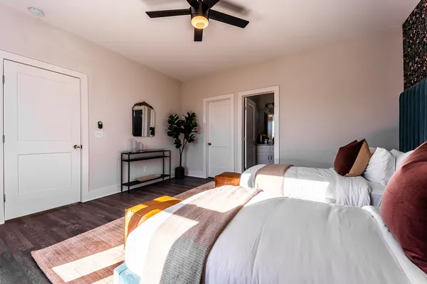 a bedroom with a bed a bookshelf and a flat tv screen