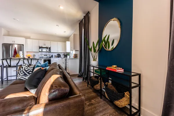 a living room with furniture a flat screen tv and kitchen view