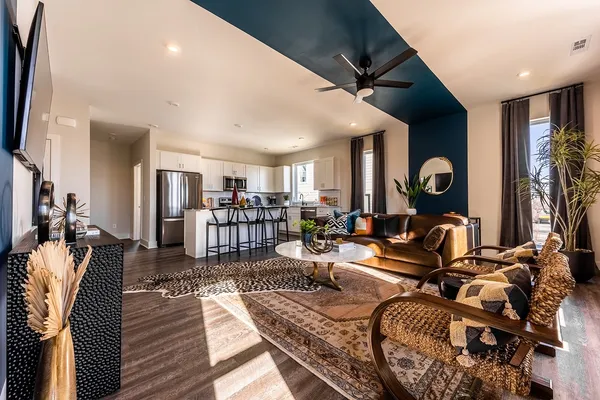 a kitchen with stainless steel appliances a table chairs refrigerator and microwave