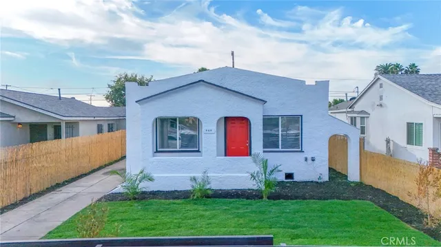 a front view of a house with a garden and plants