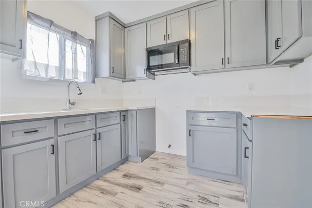 a kitchen with white cabinets stainless steel appliances and sink