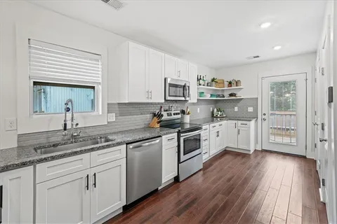 a kitchen with granite countertop white cabinets and white appliances