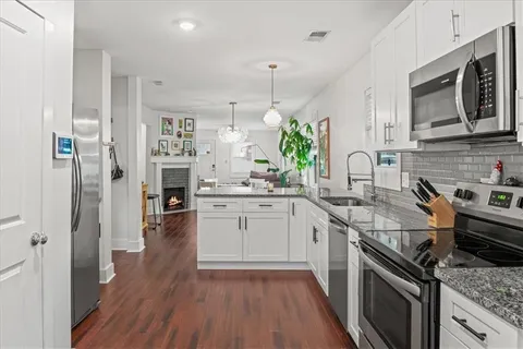 a kitchen with stainless steel appliances granite countertop a sink stove and refrigerator
