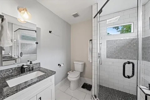 a bathroom with a granite countertop sink toilet and shower