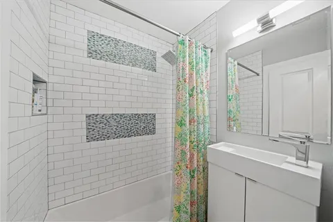 a bathroom with a shower sink and mirror