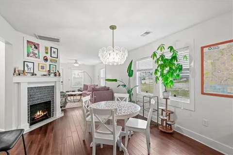 a dining room with furniture a fireplace and wooden floor