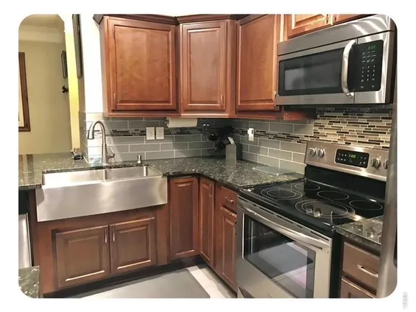 a kitchen with stainless steel appliances granite countertop a stove microwave and sink