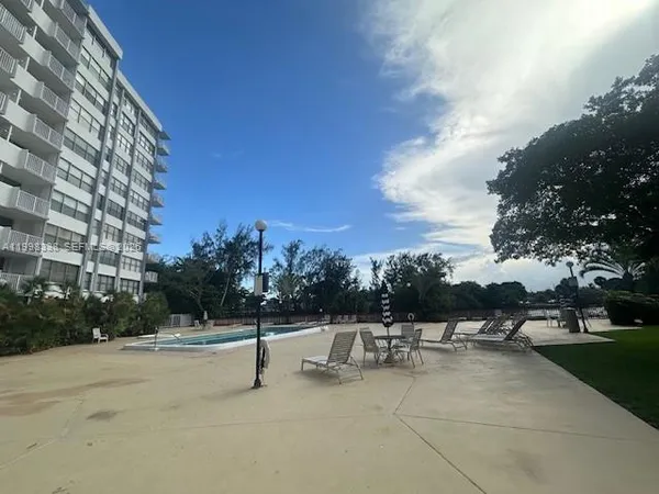 a view of a patio with a bench and trees