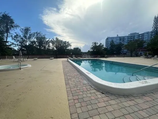 a view of a swimming pool with a yard and plants