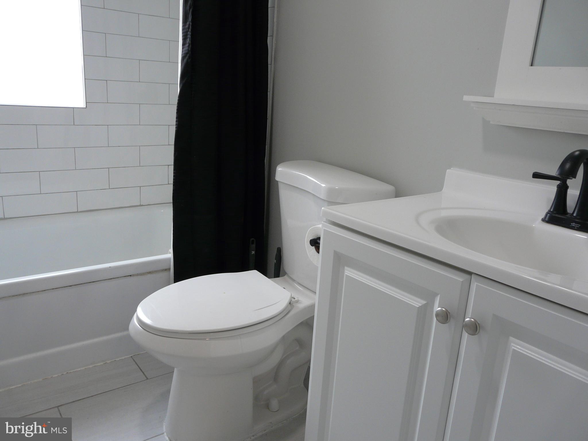 1009 Fuselage Avenue Middle River, MD 21220 - Photo 11 of 28 a white toilet sitting next to a bathroom sink