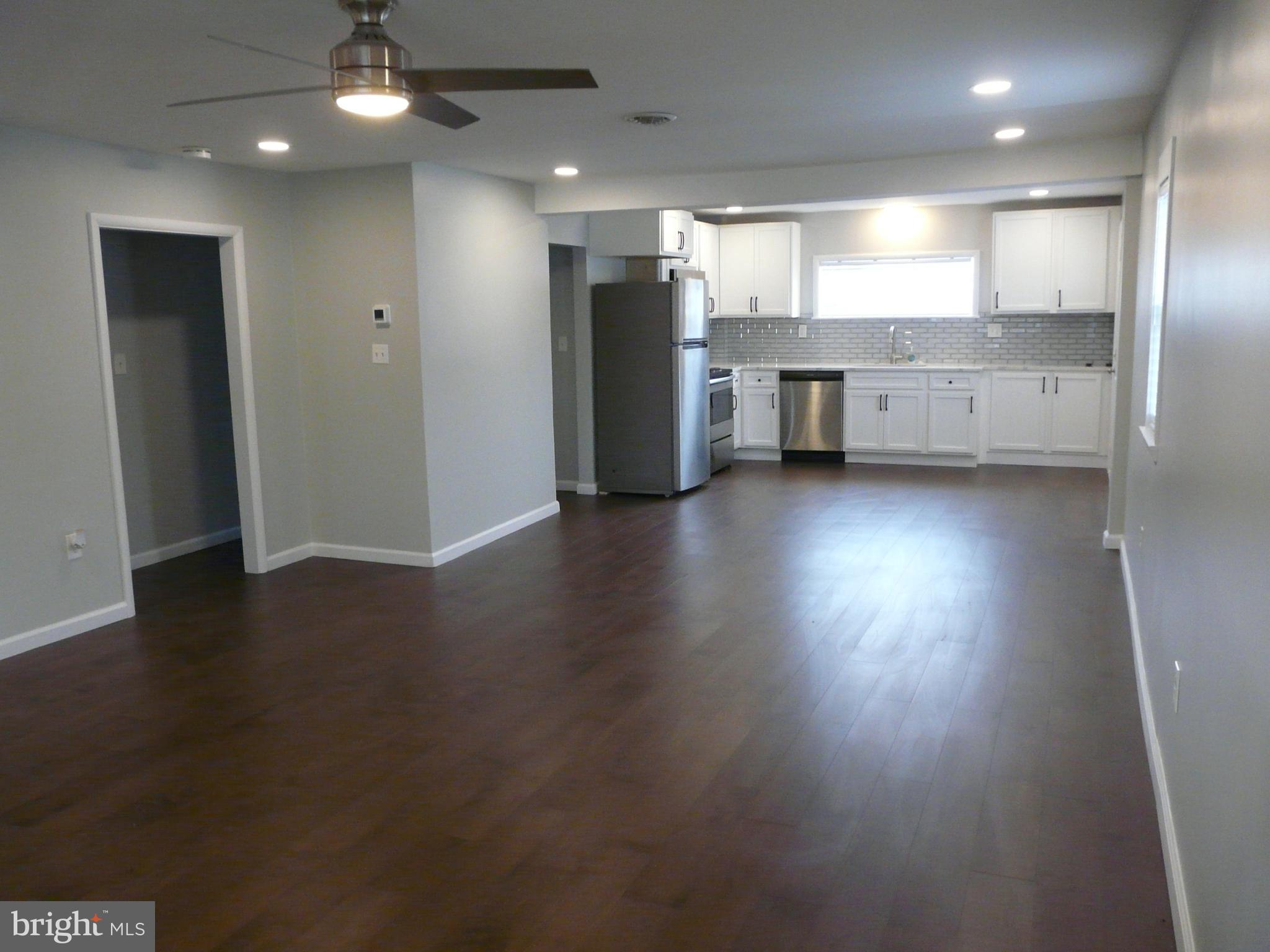 1009 Fuselage Avenue Middle River, MD 21220 - Photo 5 of 28 an empty room with a wooden floor and windows