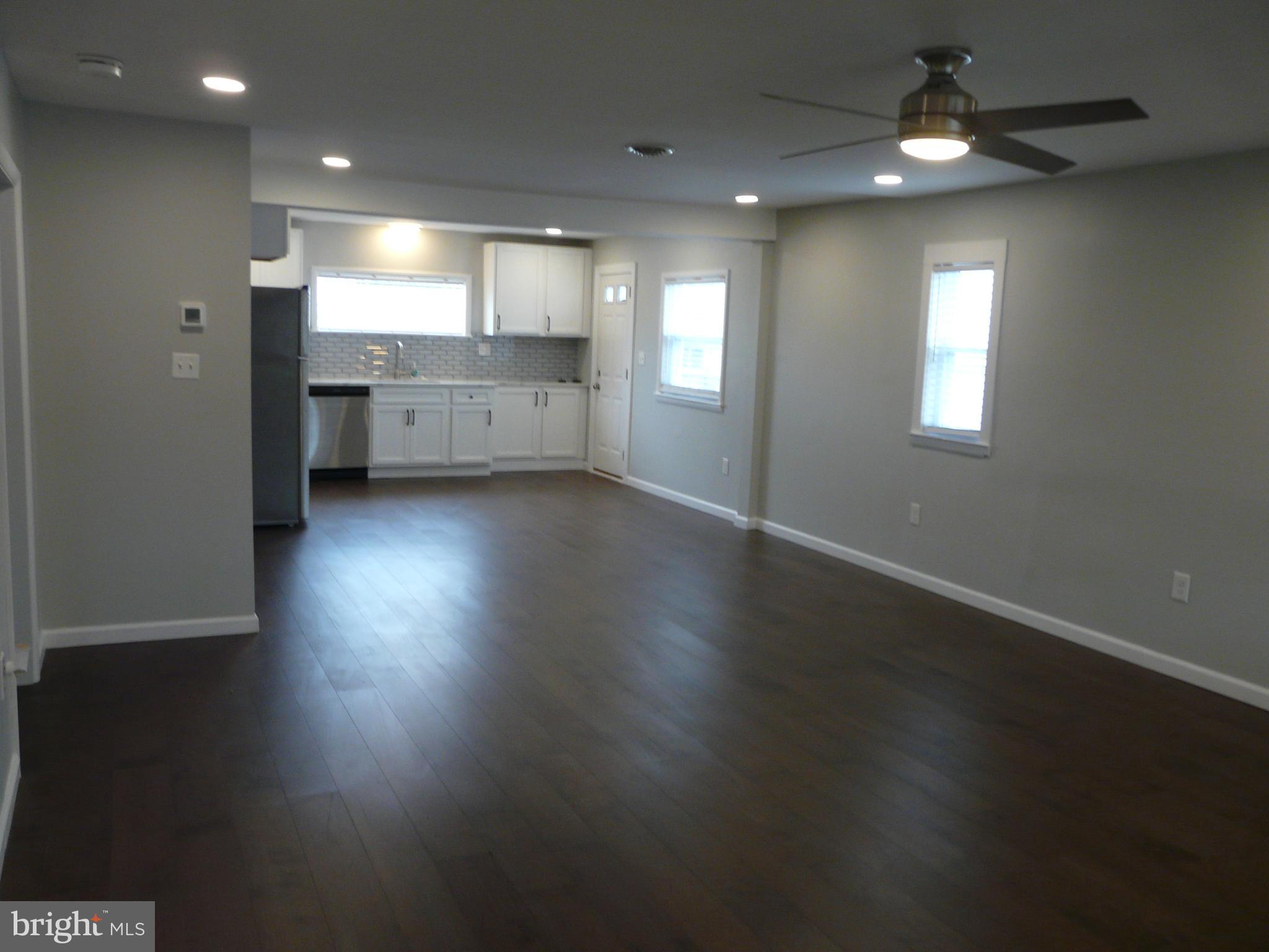 1009 Fuselage Avenue Middle River, MD 21220 - Photo 6 of 28 an open kitchen with kitchen island white cabinetry and wooden floor